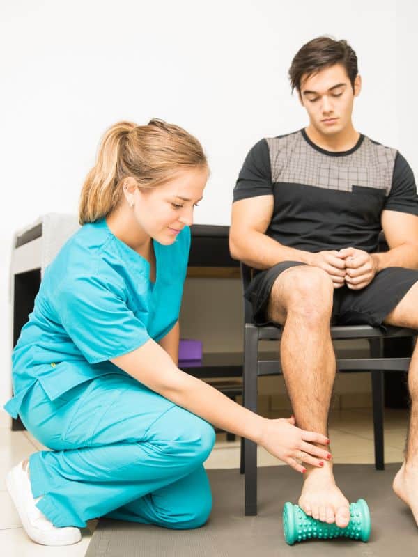 Therapist directing a patient to step on a roller